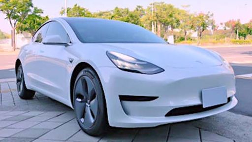 a white tesla model 3 that parking on the park